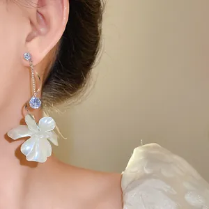 Elegante Nahaufnahme von Zirkonia-Blumen-Quastenohrringen mit perlmuttartigen Details aus Silber