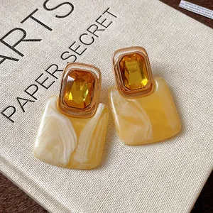 Detailansicht gelber Vintage-Kristallohrringe mit elegantem Marmor-Effekt aus Harz.