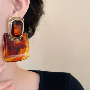 Nahaufnahme von übergroßen Vintage-Ohrringen aus bernsteinfarbenem Harz an einem Model