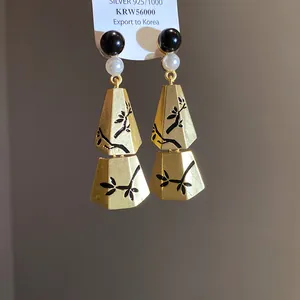 Detail of New Chinese style gold-tone earrings with black bamboo pattern and pearls