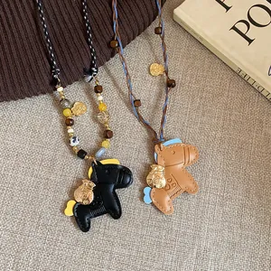 Close-up of cute leather horse pendant necklaces with wooden beads and braided cord