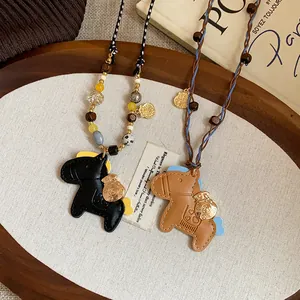 Detail view of two cute leather horse pendant necklaces featuring wooden beads and gold charms