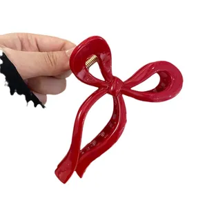 Glossy red bow-shaped hair claw clip for elegant bun hairstyles