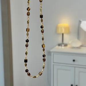 Close-up detail of a long Mallard brown tiger's eye beaded necklace for autumn winter outfits