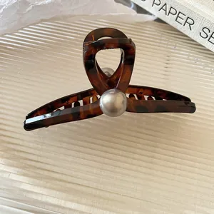 Detail of tortoise shell hair claw clip with large pearl in minimalist Korean style