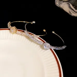 Elegant gold and silver double-row CZ cuff bracelets displayed on a white plate.