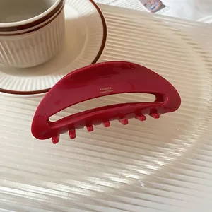 Detailed view of a glossy deep red hair claw clip with France Handmade gold stamp