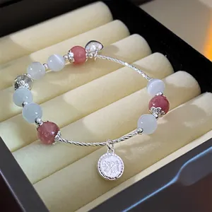 Close-up of elegant beaded bracelet with pink crystal and silver charm in gift box