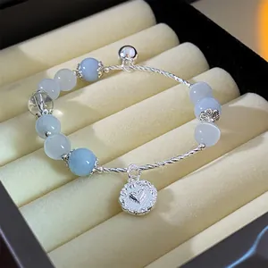 Close-up view of a delicate blue crystal beaded bracelet featuring a silver heart pendant.