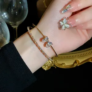 Detailed view of elegant gold double-layer bracelet with zircon butterfly on wrist