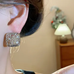 Detailansicht quadratischer, hohl gestalteter Silberohrringe mit glitzerndem Zirkon.