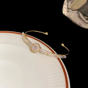 Macro view of gold-tone cuff bracelet adorned with sparkling clear baguette zircons