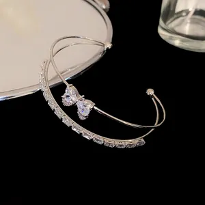Detail view of double-layer silver bangle with zircon bow and rectangular stones
