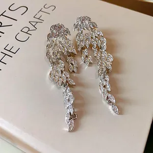 Dettaglio macro di orecchini a foglia in argento con brillanti pietre di zircone pavé