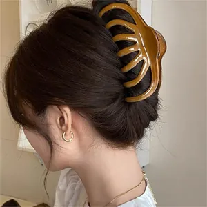 Close-up of a stylish amber wavy claw hair clip for an elegant back-updo.