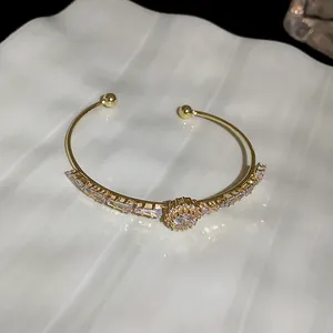 Detail shot of elegant gold cuff bracelet with sparkling cubic zirconia sunburst