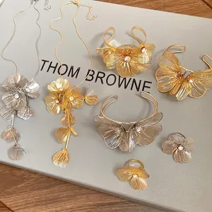 Elegant gold and silver metal hollow flower jewelry set with sparkling diamond accents