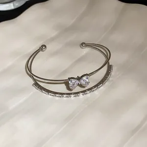 Close-up view of double-layer silver cuff bracelet with sparkling zircon butterfly charm