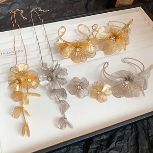Elegant floral jewelry set with hollow metal petals and rhinestones in gold and silver finishes.