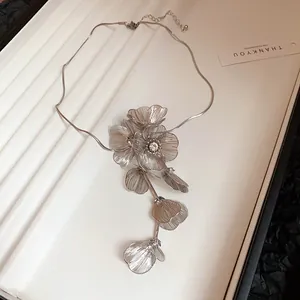 Detailed view of silver metallic hollow flower necklace with sparkling rhinestone centers
