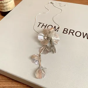 Close-up macro detail of an elegant silver-toned floral pendant necklace with crystal accents