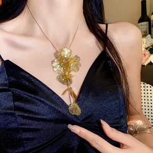 Detail view of an elegant gold metal hollow flower necklace with rhinestone embellishments