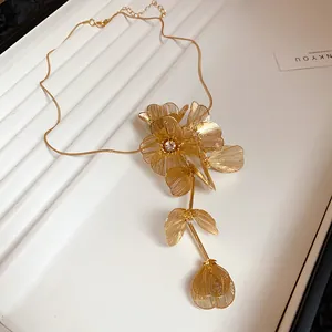 Exquisite close-up of gold hollow wire flower necklace with central rhinestone detail