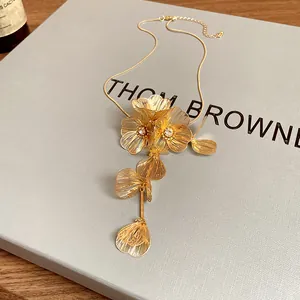 Detailed macro view of gold hollowed-out flower necklace with sparkling crystal centers