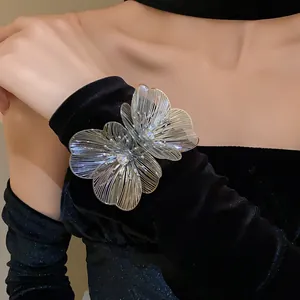 Detail view of a silver metallic hollow flower cuff bracelet with sparkling rhinestones