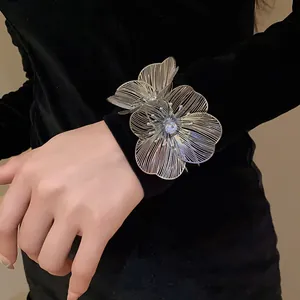 Detailed view of silver metal hollow flower bracelet featuring a sparkling center rhinestone