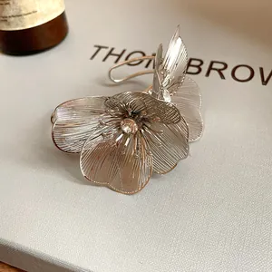 Close-up of a silver hollow-out flower cuff bracelet with a central rhinestone detail