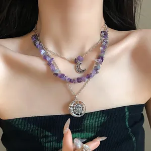 Close-up of retro layered necklace with amethyst chips and celestial sun moon pendants.