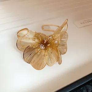 Exquisite detail of a golden filigree flower cuff bracelet featuring a central rhinestone
