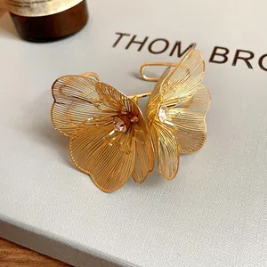 Macro detail of golden filigree flower with crystal on hollow-out metal cuff bracelet