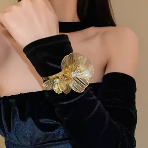 Detail of gold-tone hollow flower cuff bracelet with sparkling rhinestones