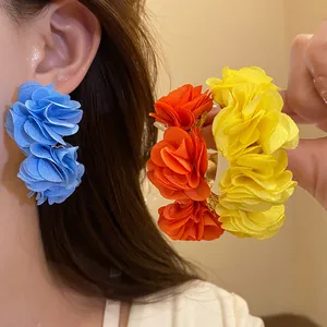 Close-up of colorful chiffon flower C-shaped earrings showing fabric texture and vibrant colors