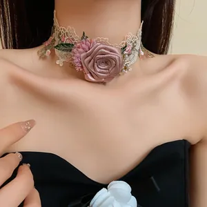 Vue détaillée d'un collier ras de cou en dentelle avec une rose rose et des perles