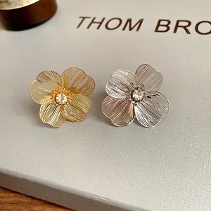 Macro view of gold and silver hollow flower bracelets with sparkling center rhinestones.