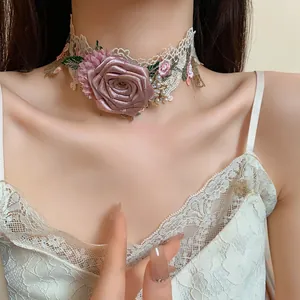 Gros plan d'un choker en dentelle florale avec une grande rose en tissu et perles.