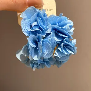 Detailed view of handmade blue chiffon fabric flower petals on C-shaped hoop earrings