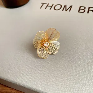 Detailed view of a gold-plated hollowed-out floral bracelet with a central sparkling stone.