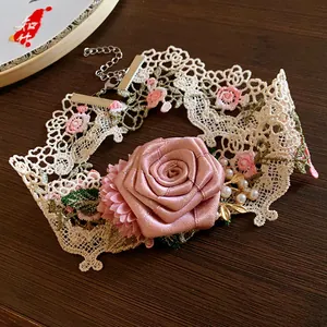 Vue détaillée d'un collier ras-du-cou en dentelle avec des roses en tissu et perles.