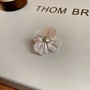 Detailed view of a silver hollow flower bracelet with a crystal center