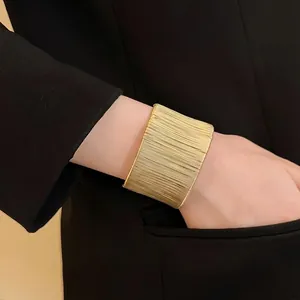 Brazalete abierto envuelto en hilo dorado de lujo para un look de moda minimalista