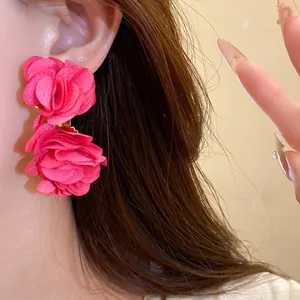 Detail shot of elegant bright pink chiffon flower earrings on an Asian model's ear