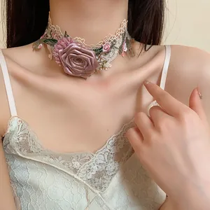 Gros plan détaillé d'un tour de cou en dentelle avec rose vintage et perles fines.