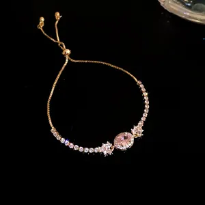 Detailansicht eines verstellbaren Goldarmbands mit einem ovalen rosa Zirkonia-Stein