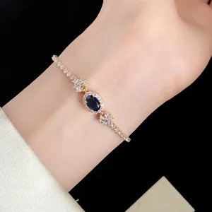 Detailansicht eines eleganten Goldarmbandes mit blauem Stein und Zirkonia.