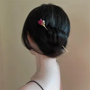 Détail d'une épingle à cheveux avec rose éternelle dans un chignon