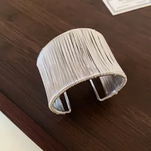Vista detallada del diseño de alambre de plata enrollado en capas de este brazalete.